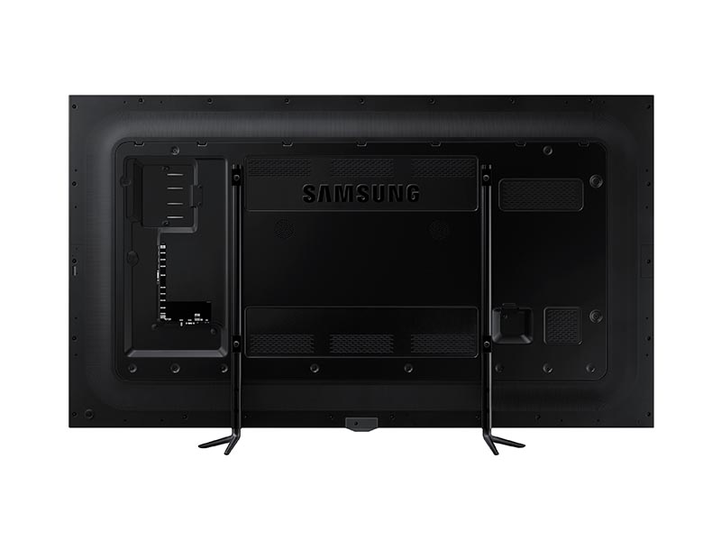 Rear view of the 95 Inch LED LCD Samsung ME95C for rent, featuring the Samsung logo, multiple input ports, ventilation grilles for cooling, and two sturdy support stands at the bottom.