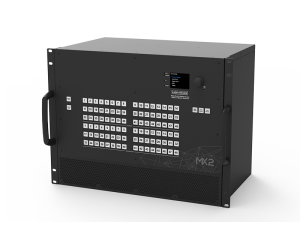 Lightware MX2 black rectangular electronic device with two side handles, a front panel featuring a labeled button grid, a small digital display screen showing text, and the “Lightware MX2” label; used for professional AV signal management.