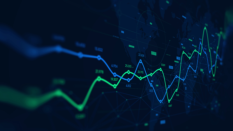 Digital graph illustrating financial or stock market trends, with blue and green fluctuating lines over a dark world map background, featuring numbers and grid lines.