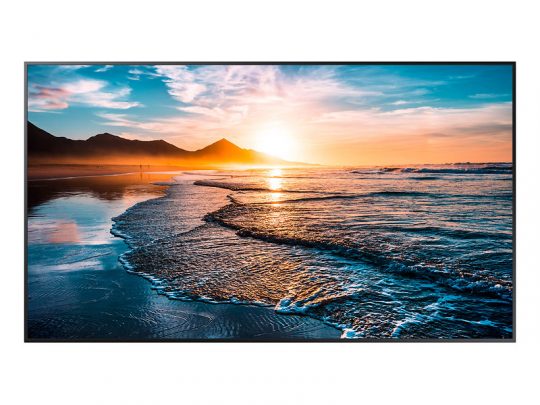 Vibrant sunset over ocean wall art print—depicts gentle waves on a sandy beach with distant mountains silhouetted against a colorful sky in shades of blue, orange, and pink. Perfect coastal decor for living room or bedroom.