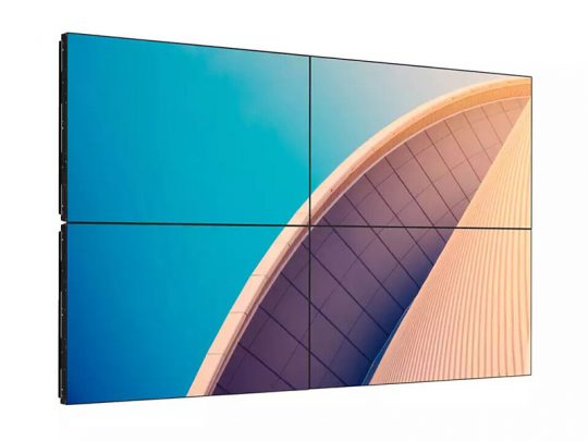 Video wall display of four flat screens showing an abstract architectural photo with curved, ribbed structures set against a bright blue sky. Ideal for digital signage or large-scale visual presentations.