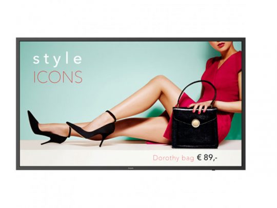 A woman in a red dress sits with crossed legs, holding the black Dorothy handbag. Text reads style ICONS and Dorothy bag €89, on a light blue and white background.