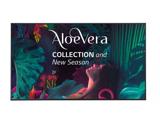 A vibrant advertisement for the Aloe Vera Collection shows a woman looking upward, surrounded by lush tropical leaves and colorful flowers. Bold white text reads Aloe Vera COLLECTION and New Season 2F, highlighting a new product launch.