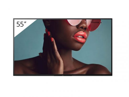 55-inch flat-screen TV displaying a vibrant close-up of a woman with dark skin, pink sunglasses, orange lipstick, and matching orange nail polish on a blue background. The TV showcases vivid colors and high-definition detail—ideal for home entertainment.