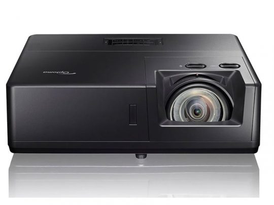 Black Optoma projector with a large lens and top control buttons, displayed on a white background.