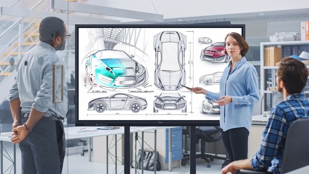 Eine Frau präsentiert am 86 Zoll UHD Multi Touch Display Optoma 3862RK (Neuware) in einem modernen Büro Car Design Skizzen ihren fokussierten Kollegen; zusammen besprechen sie innovative Sportwagen-Konzepte für zukünftigen Verkauf oder Vermietung.