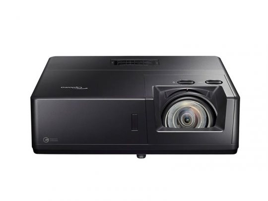 Optoma Beamer in Schwarz: Das Bild zeigt einen schwarzen Optoma Projektor mit großer Linse vorne rechts, Bedienknöpfen oben und einem modernen, rechteckigen Gehäuse. Ansicht von vorne vor weißem Hintergrund.